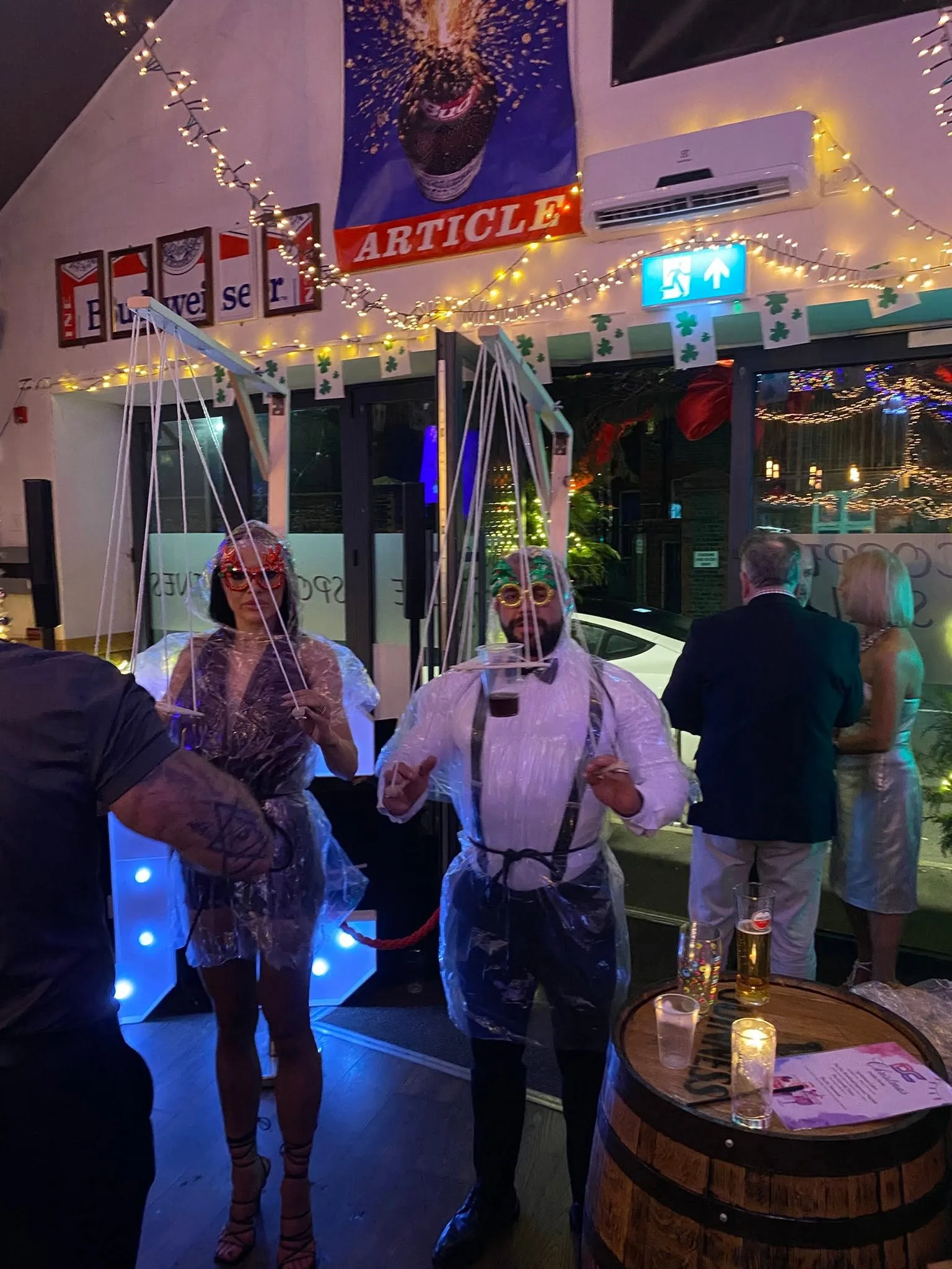 Two people using Beer Puppeteer frames at an indoor party