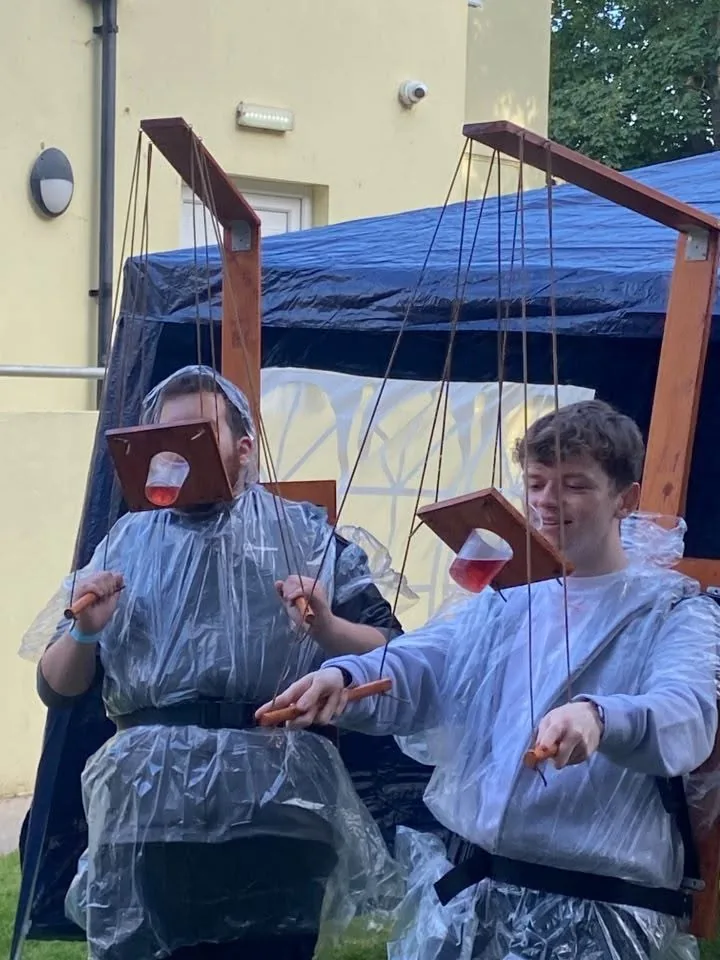 Two people trying the Beer Puppeteer together outside