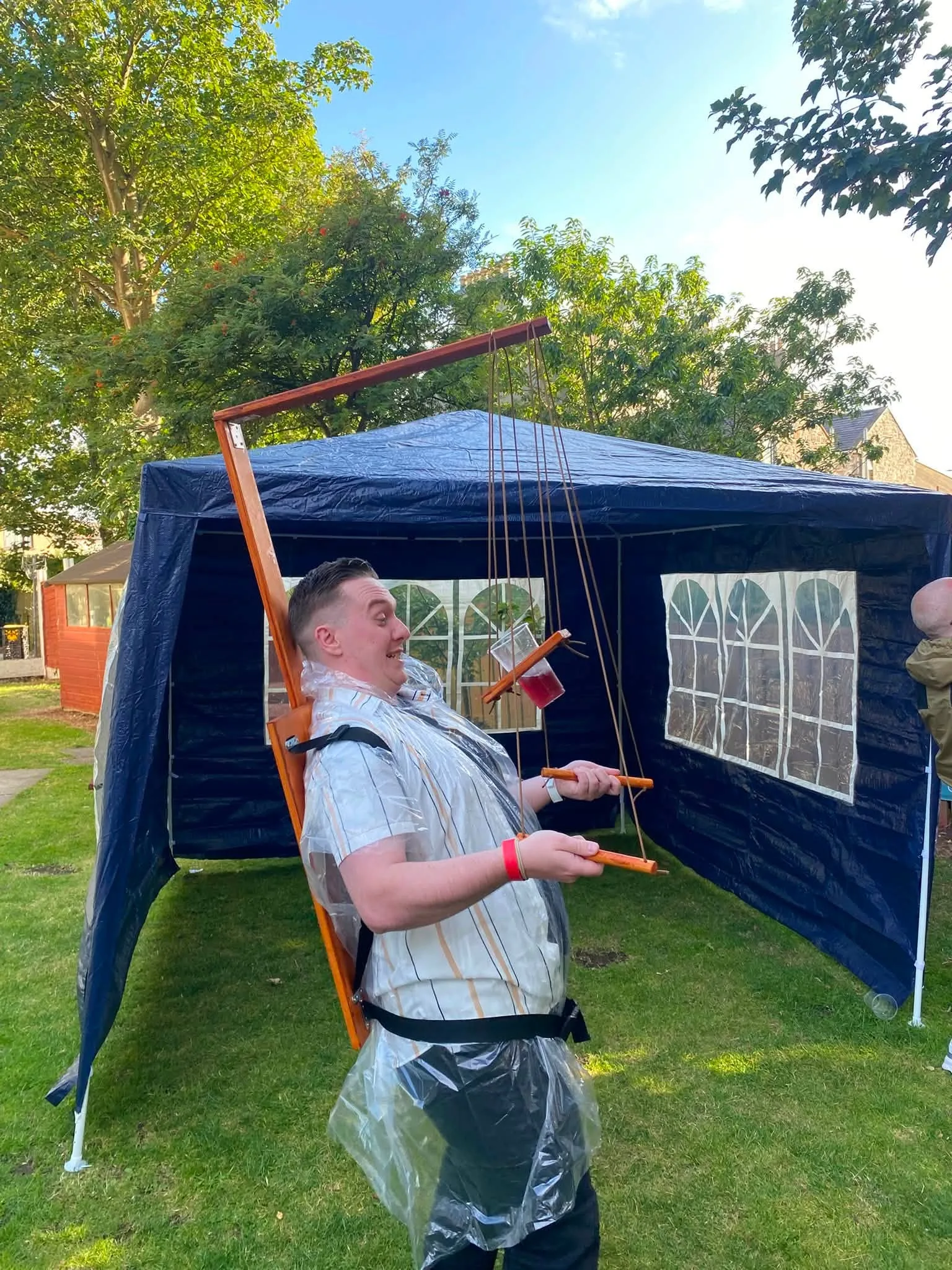 A man trying the Beer Puppeteer at a garden party