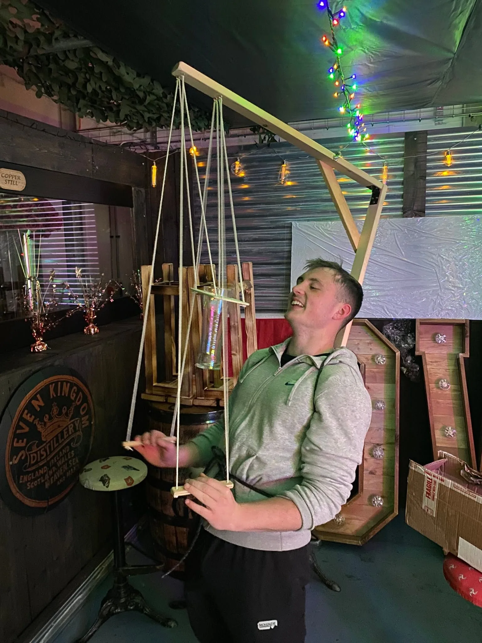 A man smiling while using the Beer Puppeteer indoors