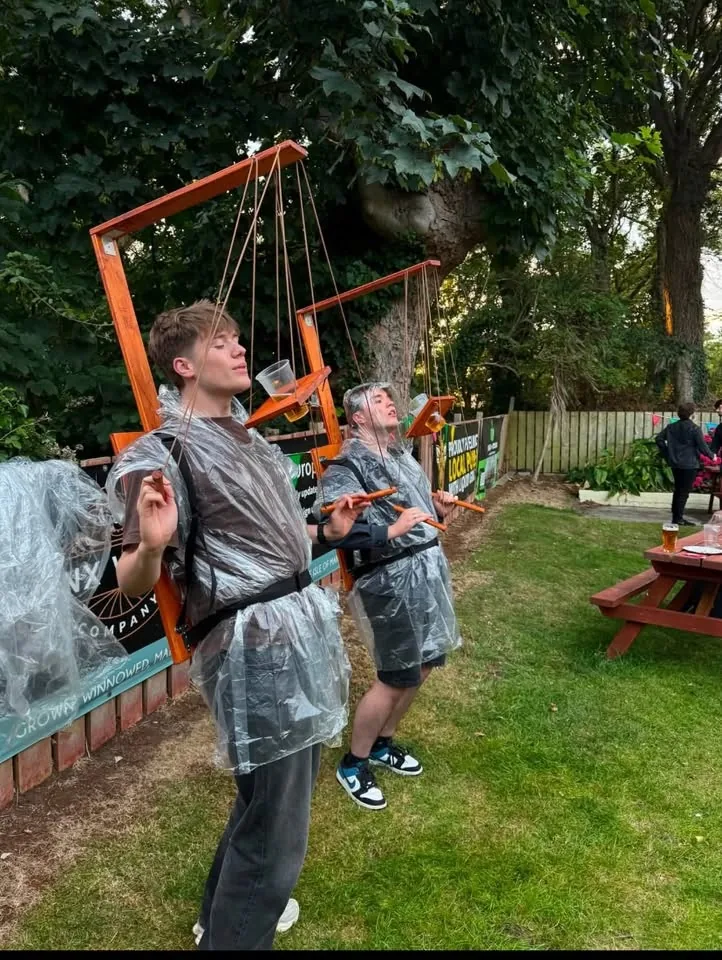 Two people concentrating while using Beer Puppeteer frames outside